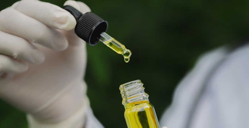 person-dropping-CBD-oil-from-glass-pipette-into-glass-bottle.jpg