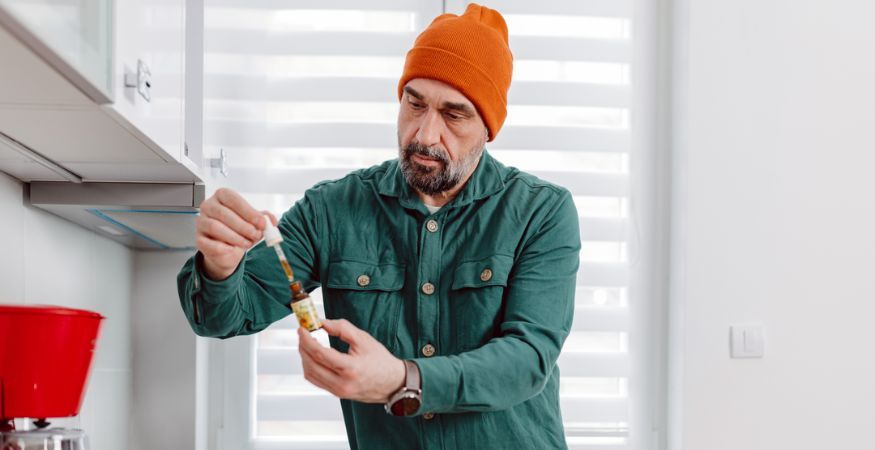 man-holding-bottle-and-pipette-with-CBD-oil.jpg