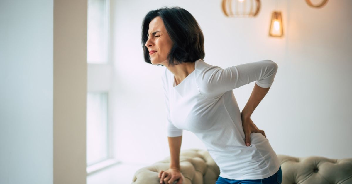 Woman holding her lower back in pain.