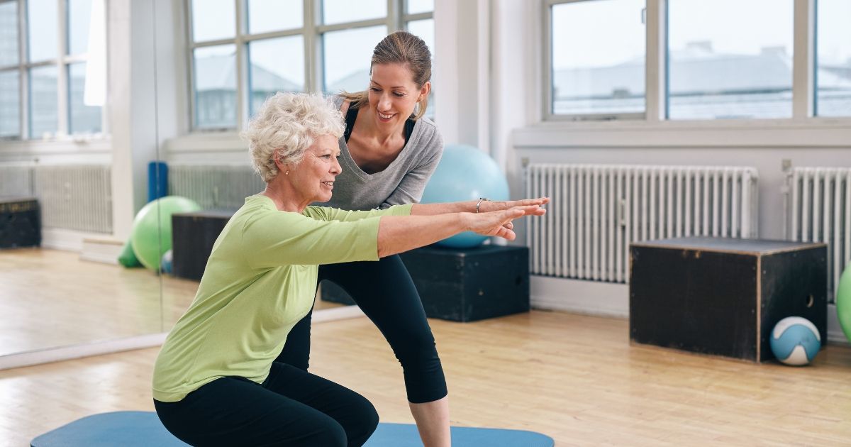 elderly women doing exercise with a trainer