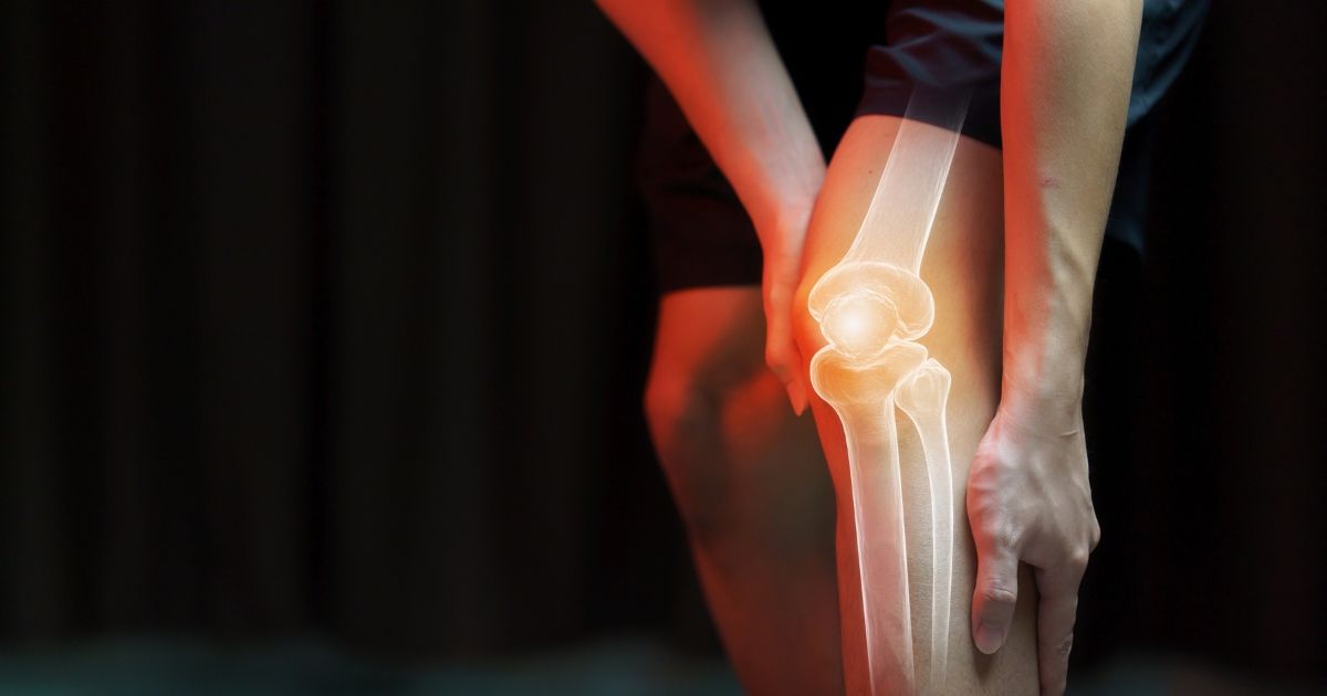 person holding their knee because of joint pain