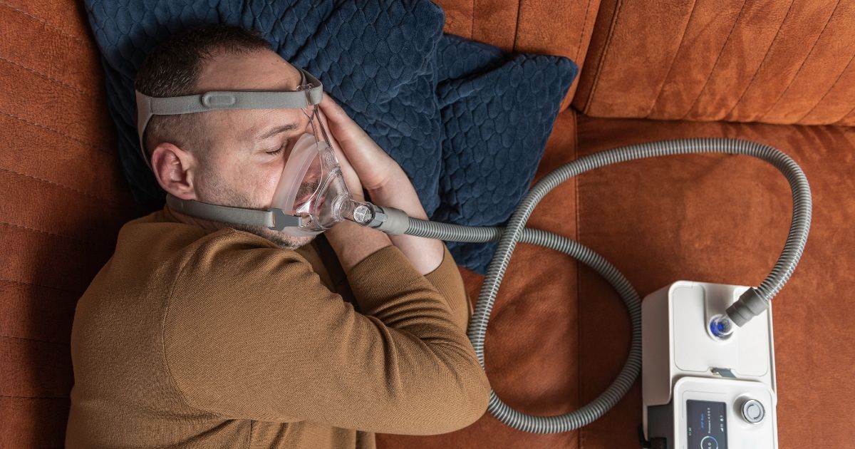 man sleeping with a CPAP machine next to him