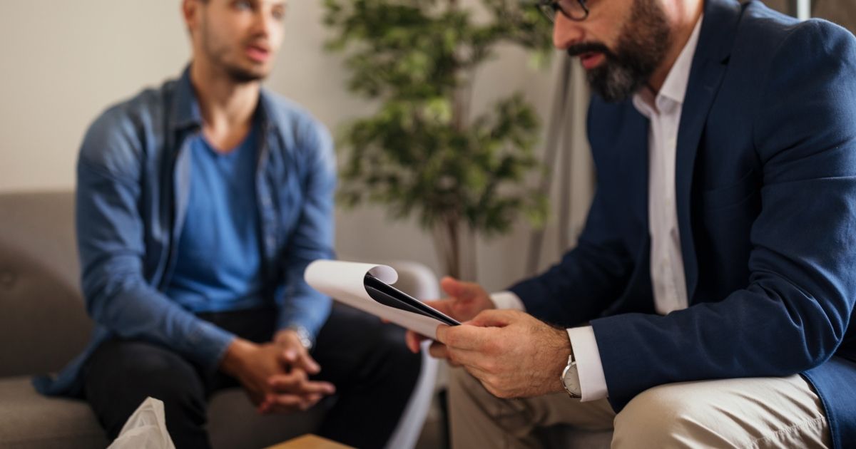 man in blue jacket having a therapy session with therapist in a suit